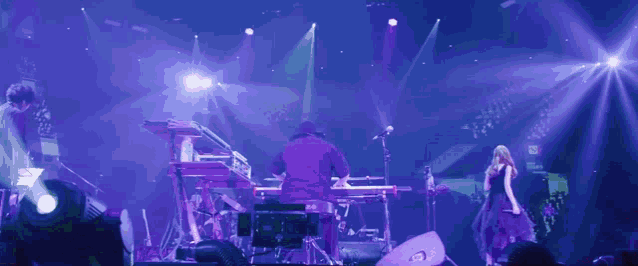 a man sits on a drum stool in front of a yamaha keyboard on a stage