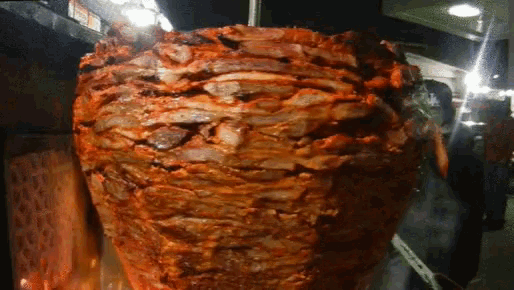 a large amount of meat is being cooked on a spit