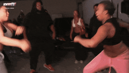 a group of people are dancing in front of a sign that says now thats tv