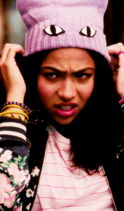 a woman wearing a purple beanie with cat eyes on it