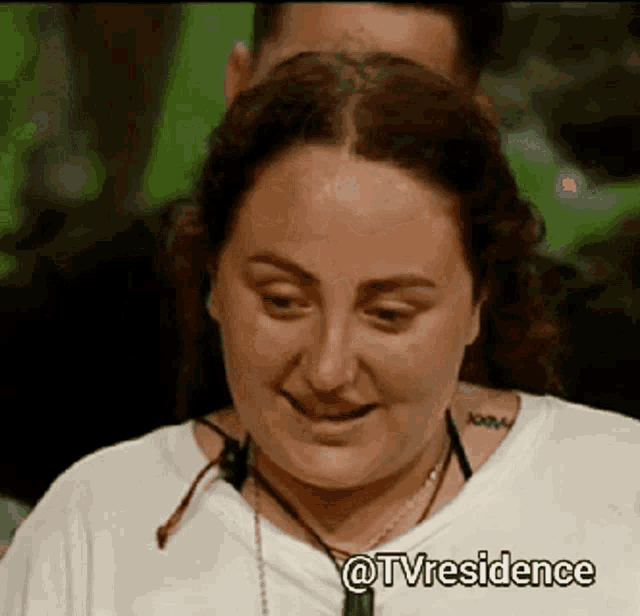 a woman wearing a white shirt and a necklace is smiling with a caption that says tvresidence