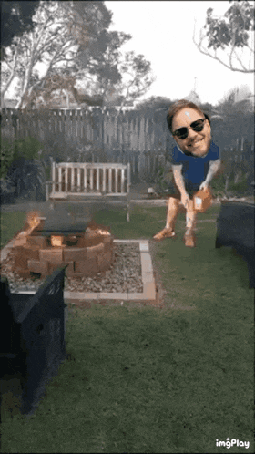 a man in sunglasses is standing in front of a fire pit in a backyard
