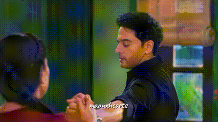 a man and a woman are holding hands and dancing in a living room .