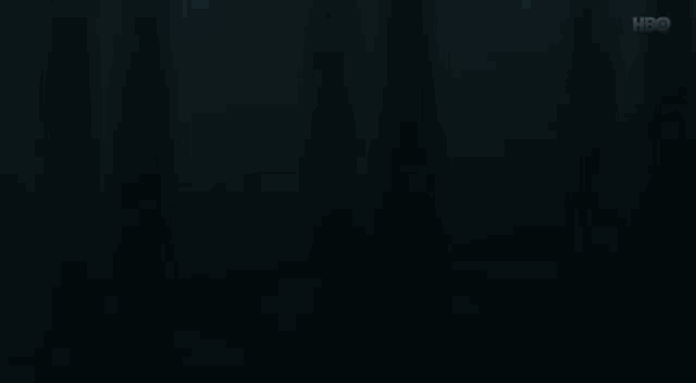 a man in a suit is standing in front of a window in the dark .