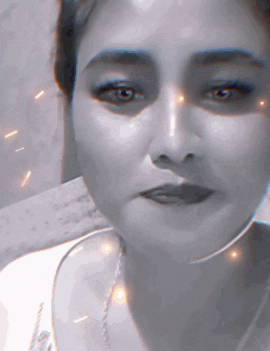 a close up of a woman 's face with sparks coming out of her eyes