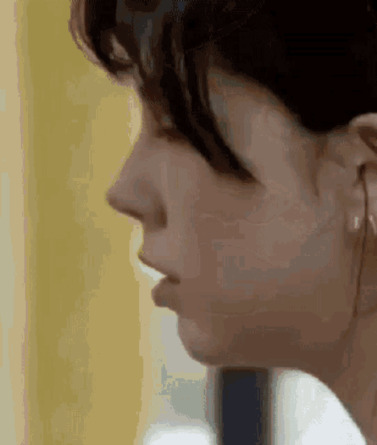 a close up of a woman 's face with her mouth open and a yellow background .