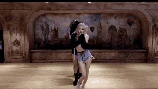 a woman is dancing in front of a wall with hot air balloons in the background