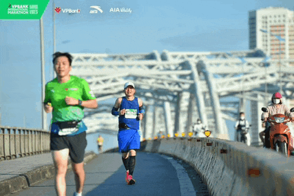 a man in a green shirt is running on a bridge sponsored by aia
