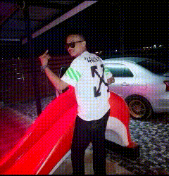 a man wearing a white shirt with the letter x on it