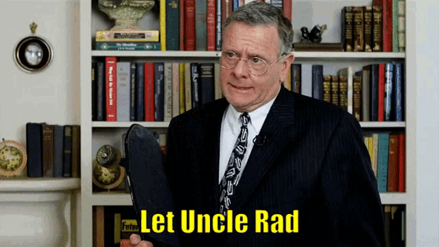 a man in a suit and tie stands in front of a bookshelf with the words let uncle rad above him