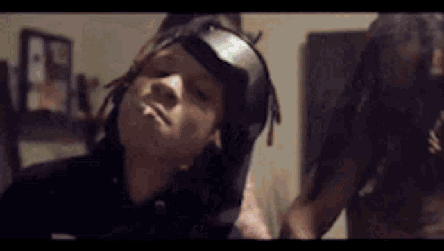 a man with dreadlocks is wearing a mask on his head and a woman is standing next to him .