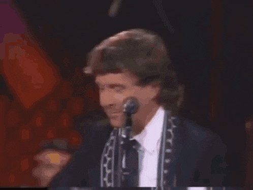 a man is playing a guitar and singing into a microphone .