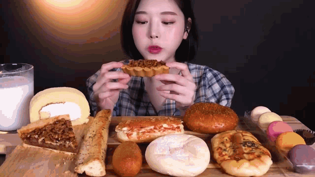 a woman is sitting at a table eating bread