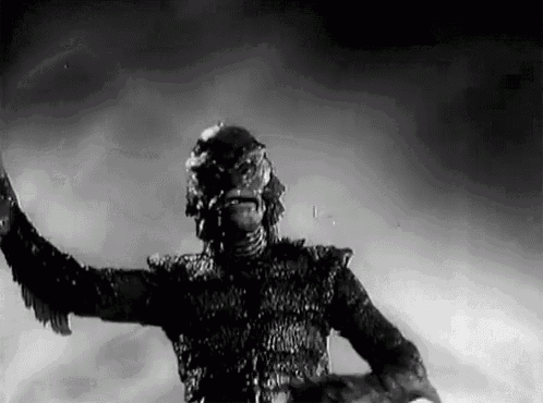 a black and white photo of a monster with its arms outstretched in the air .