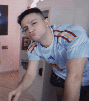 a man wearing a light blue adidas shirt makes a funny face