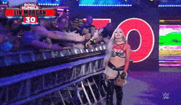 a wrestler named liv morgan is standing in front of a crowd of people
