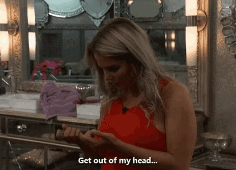 a woman in a red dress is looking at her nails and says get out of my head