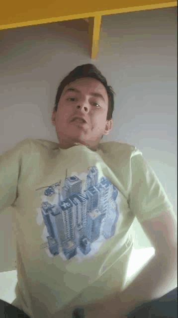 a man wearing a green t-shirt with a picture of a city on it