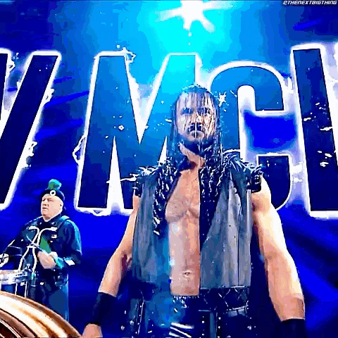a man with dreadlocks is standing in front of a sign that says wwe .