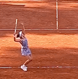 a woman in a blue dress is swinging a tennis racket