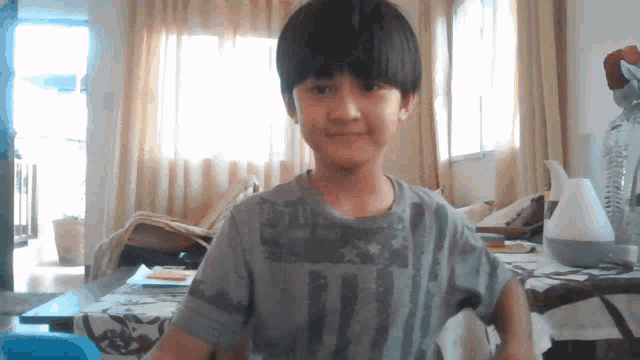 a young boy wearing a gray shirt that says ' united states of america ' on it