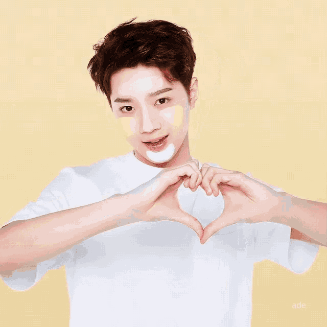a young man making a heart shape with his hands