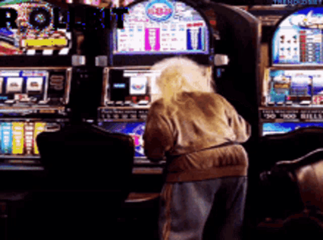 an elderly woman is playing a slot machine with the word roulette on the screen