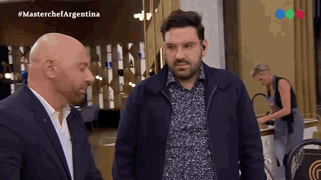 two men are standing in front of a screen that says masterchefargentina