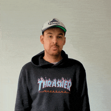 a man wearing a thrasher hoodie and a hat