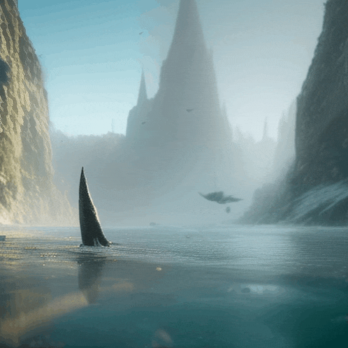 a shark 's tail is visible in the water near a mountain