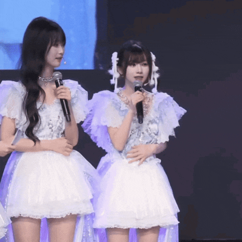 a girl in a white dress holds a microphone