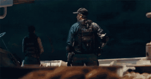 a man in a superhero costume is holding a shield in his hands .