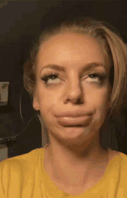 a woman in a yellow shirt making a face