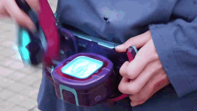 a person is holding a purple and blue item with a blue light on it .