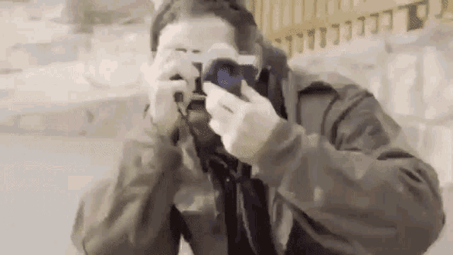 a man is taking a picture with a camera in his hand .