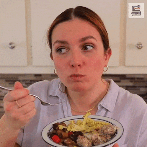 a woman eating a bowl of food with a fork