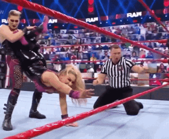 a wrestler is being lifted in the air by another wrestler in a wrestling ring