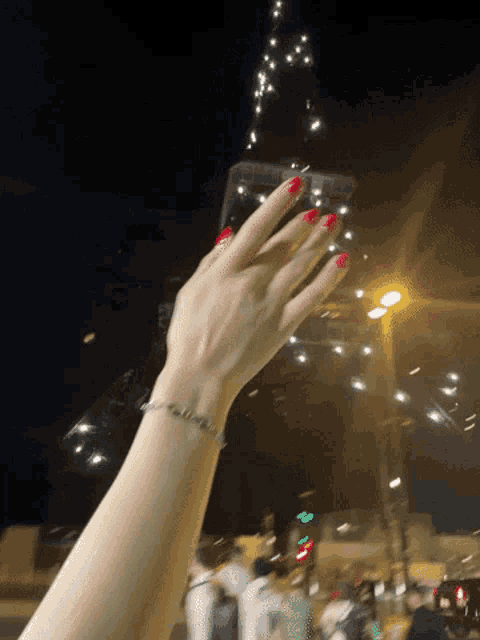 a woman 's hand with red nails and a bracelet that says california