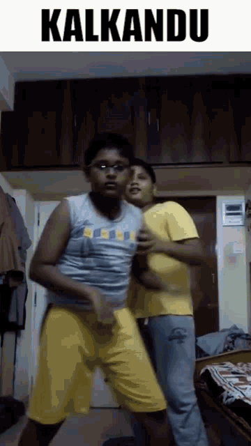 two young boys are dancing in a room with the word kalkandu above them