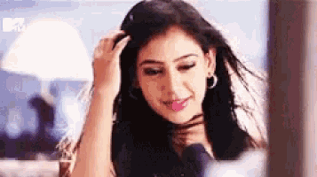 a woman is looking at herself in the mirror and smiling .