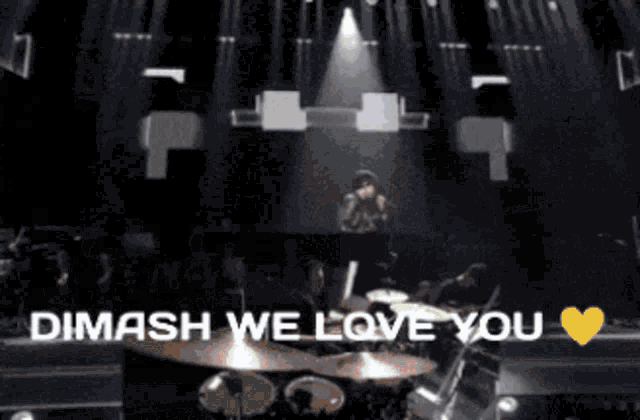a blurred image of a concert with the words " dimash we love you " at the bottom