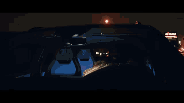 a man is sitting in a car with a lamborghini logo on the back seat