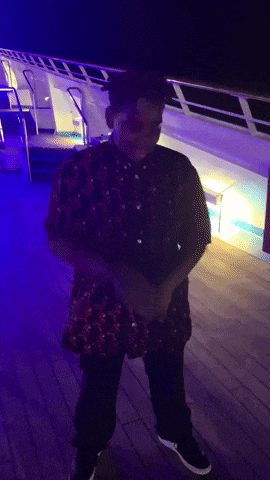 a man in a red shirt and black pants is standing on a deck