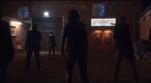 a group of people standing in front of a building with a sign that says american legion .