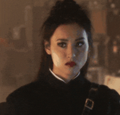 a close up of a woman 's face with a black jacket and red lips .