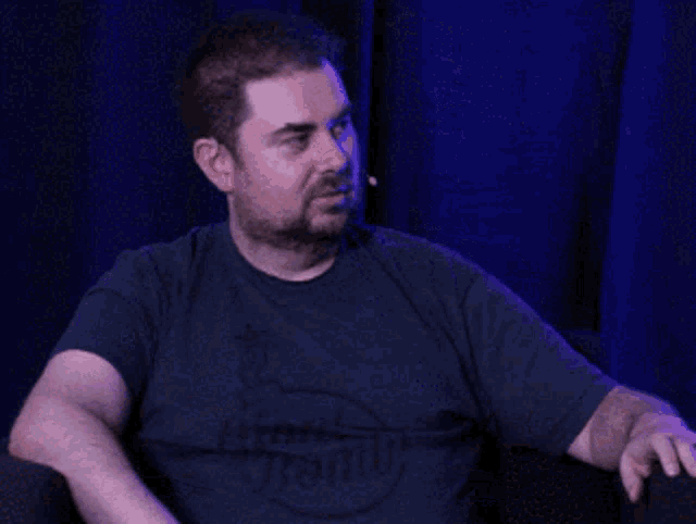 a man sitting in a chair with his hands folded in front of him