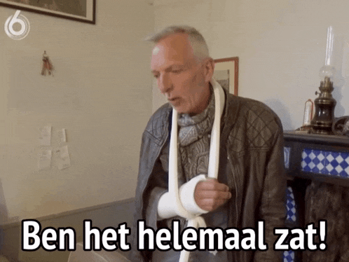 a man with a cast on his arm is standing in front of a fireplace and says ben het helemaal zat
