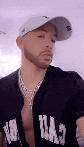 a man wearing a baseball cap and a shirt that says ' miami ' on the front