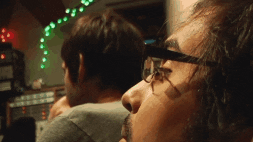 a man wearing glasses looks at something in the distance