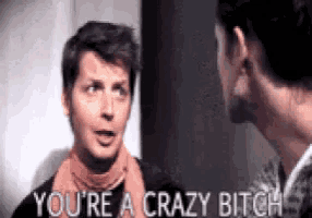 two men are talking to each other and one of them is saying you 're a crazy bitch .